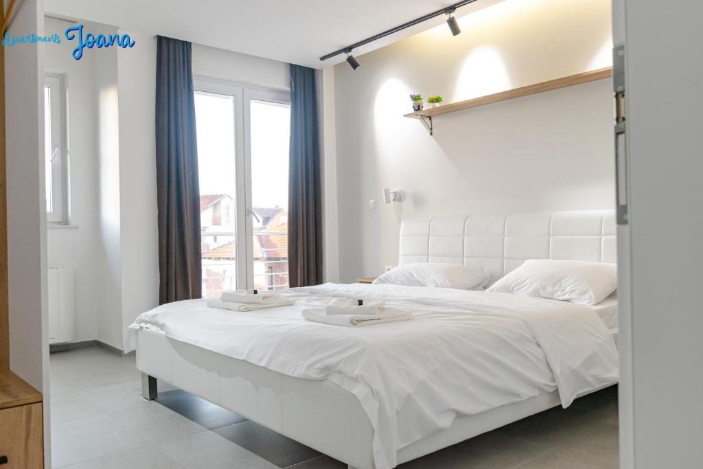 Bright, modern bedroom at Apartments Joana with a private balcony over Ohrid